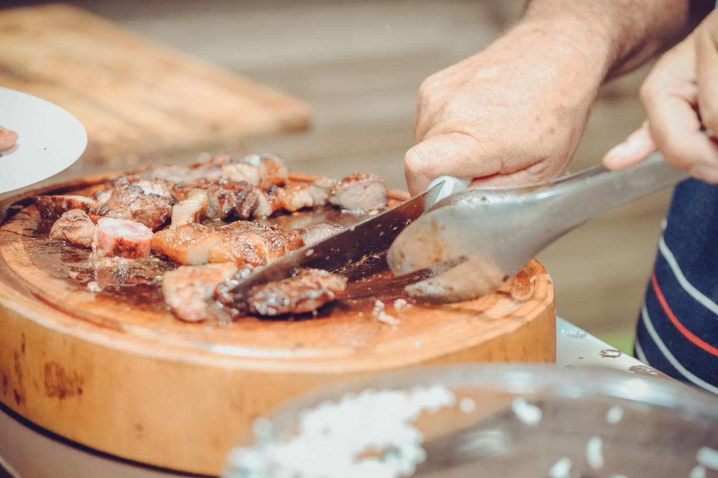A long slicing knife cutting a smoked brisket against the grain