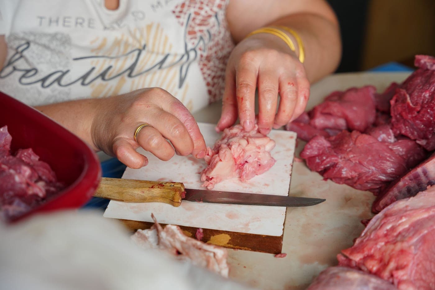 Trimming the fat cap off a raw brisket with a boning knife
